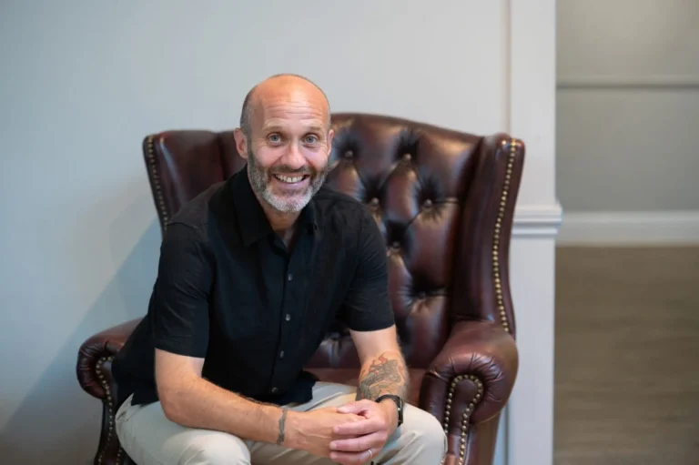 John Lewis smiling in a leather armchair