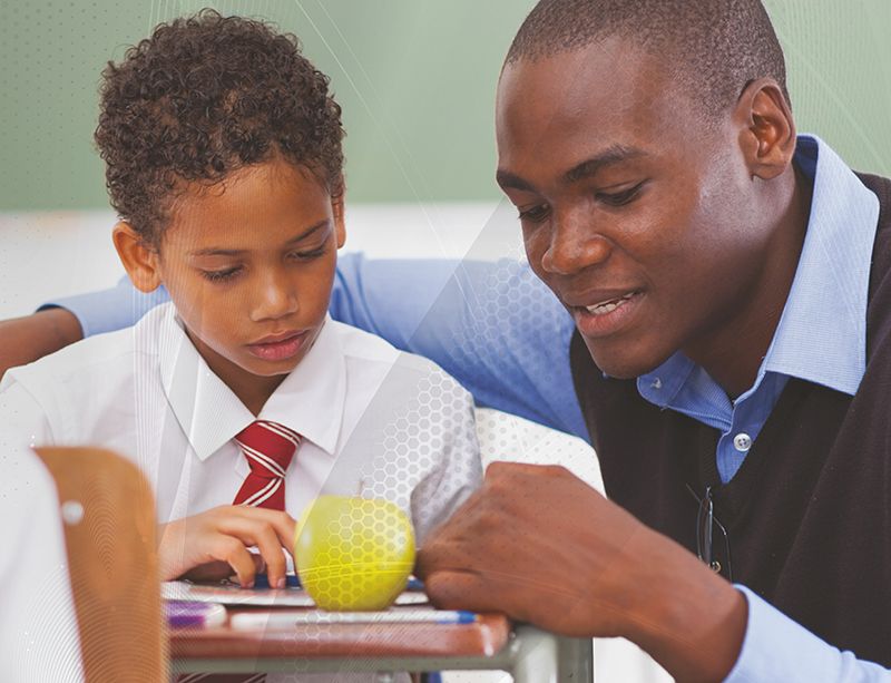 Adult helping a schoolboy with his work