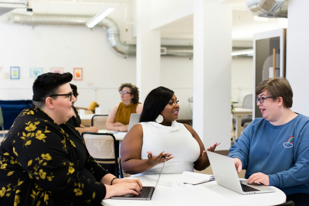 Three colleagues talking and laughing around a table