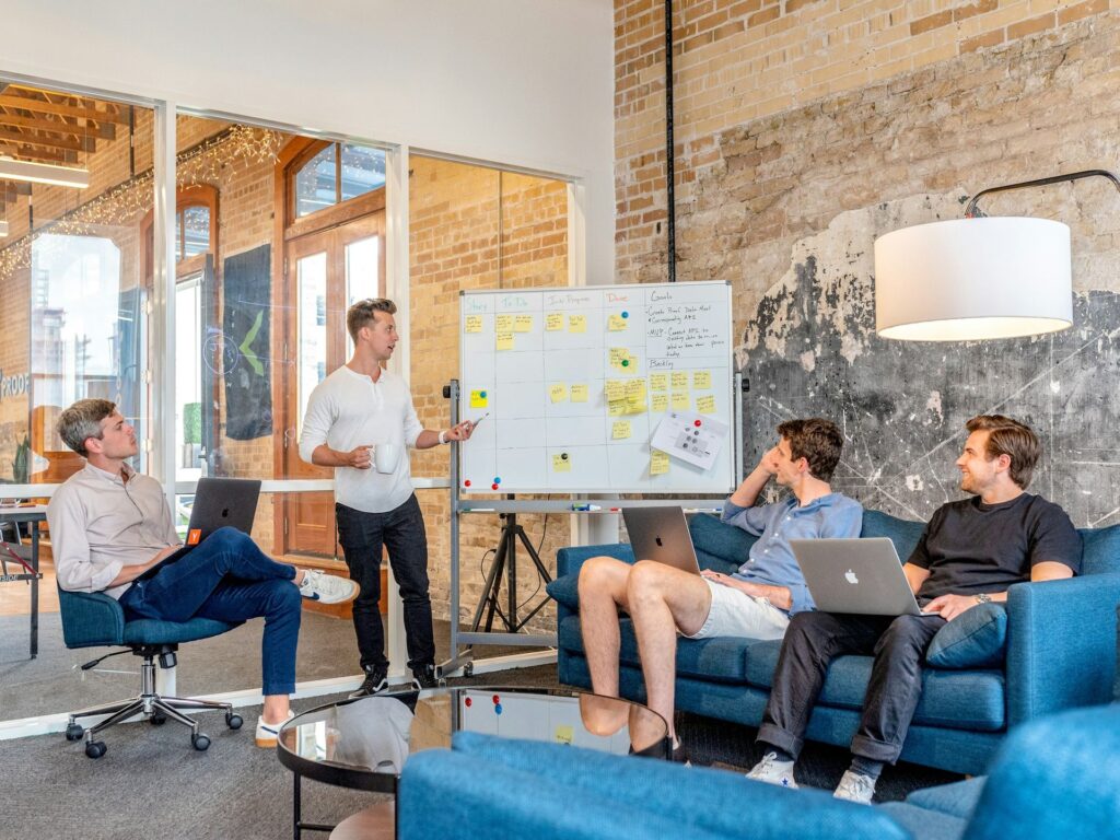 A facilitator at a whiteboard running a workshop for a small team